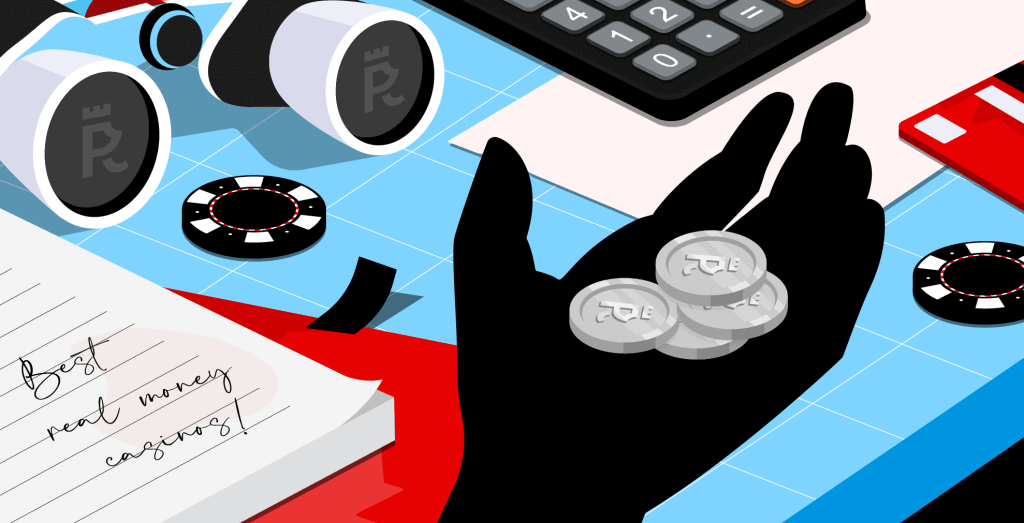 A hand holding some Casinopro coins in front of a table with a note reading 'Best Real Money Casinos' along with casino chips, a calculator and a pair of binoculars